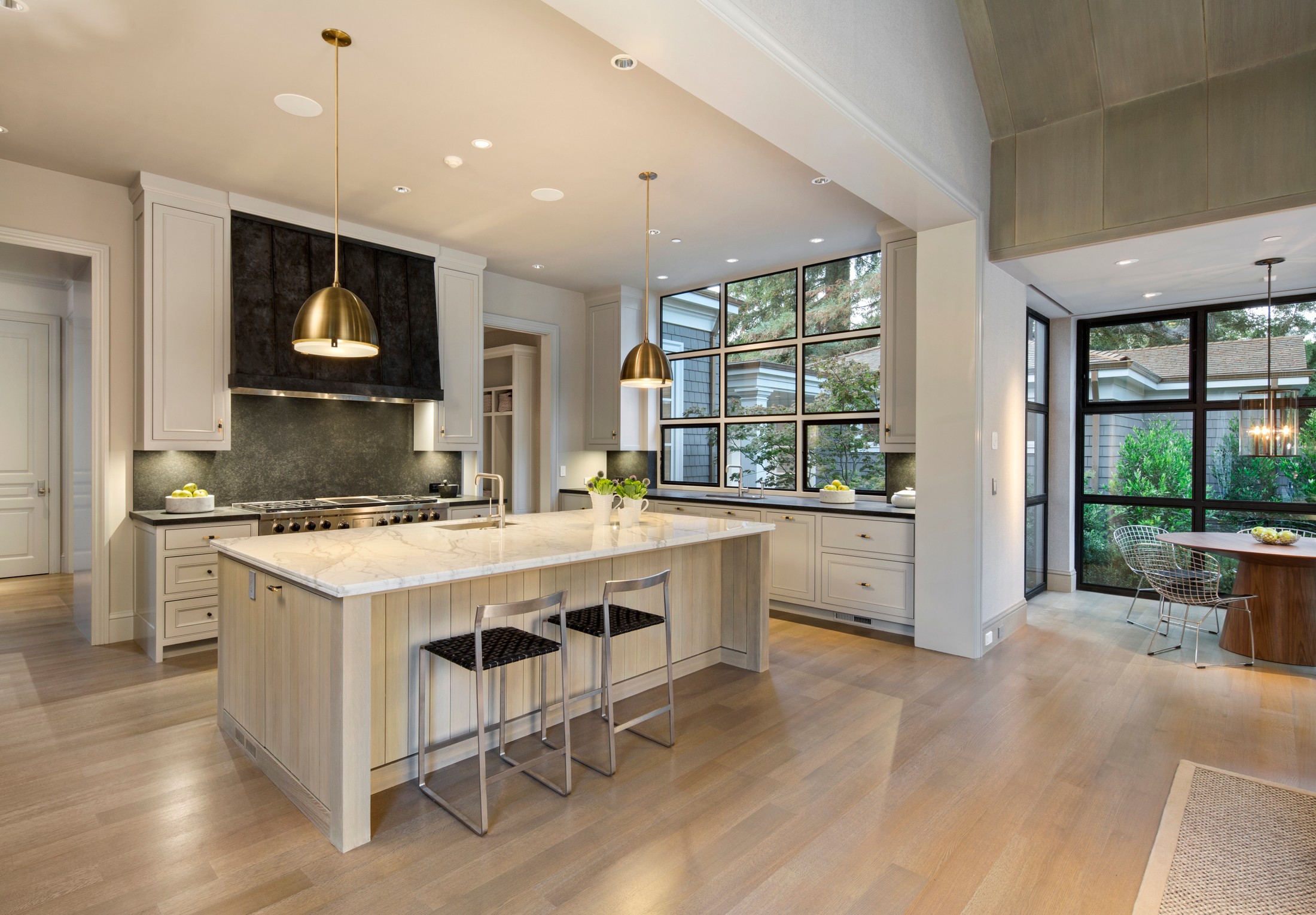 Kitchen with marble and wood island and gold hanging lamps