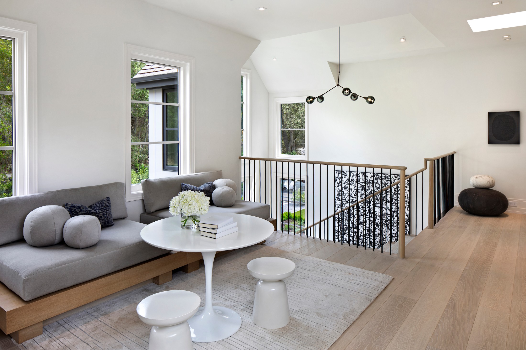 Upstairs seating area, with two-seat sofa and white circular table.