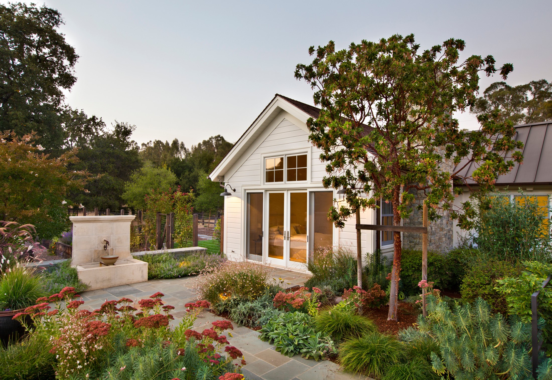 Backyard shot of a walkthrough garden, with square paved stone.