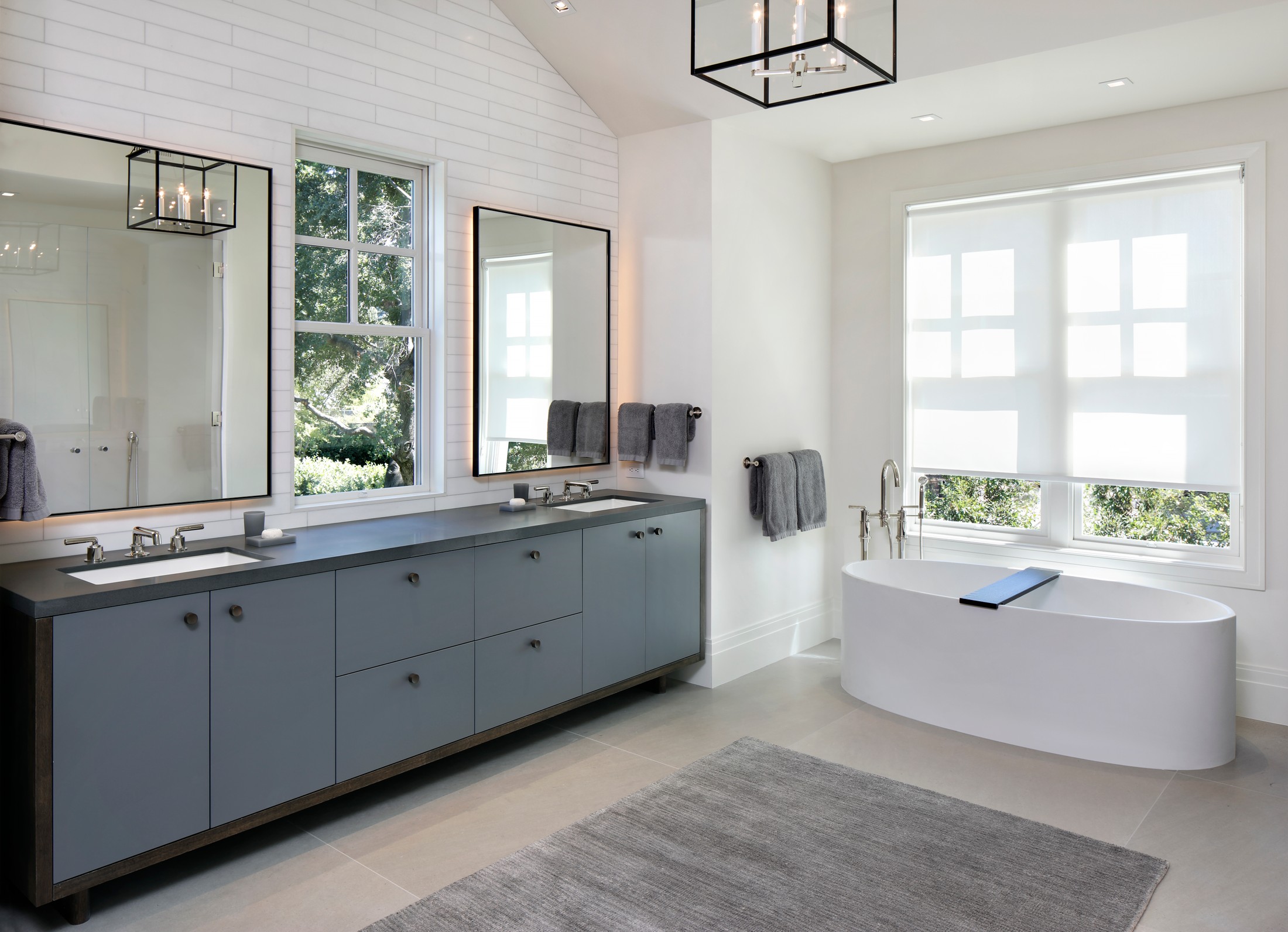Upstairs bathroom with cabinetry with two sinks, white bathtub and carpet